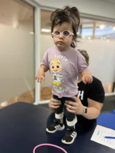 Mia, Trisomy 18 child, doing standing therapy
